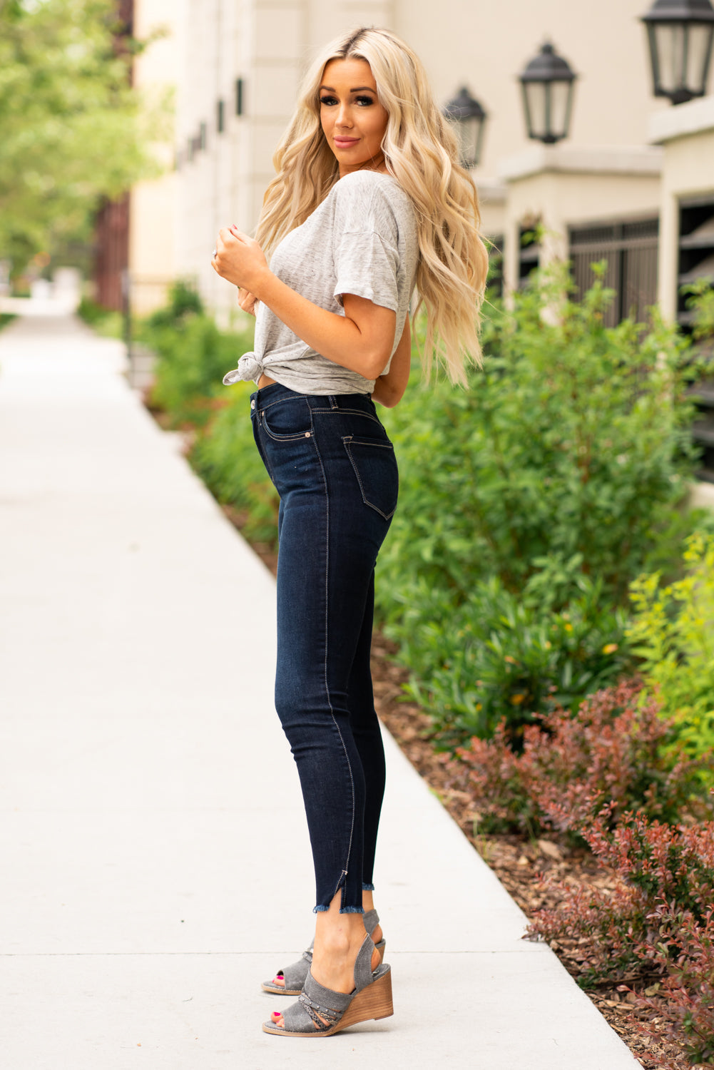 KanCan Jeans These high rise dark wash skinny jeans have a spilt fray hem and fit above the ankles so you can show off you sandals this summer. Color: Dark Blue Cut: Skinny, 27.5" Inseam Rise: High-Rise, 10.5" Front Rise COTTON 71% POLYESTER 27% SPANDEX 2% Stitching: Classic Fly: Zipper Style #: KC8604D Contact us for any additional measurements or sizing. Cas is 5'7", wears a size 25 jeans, small top and 8 shoe. She is wearing a size 25/3 in these jeans.