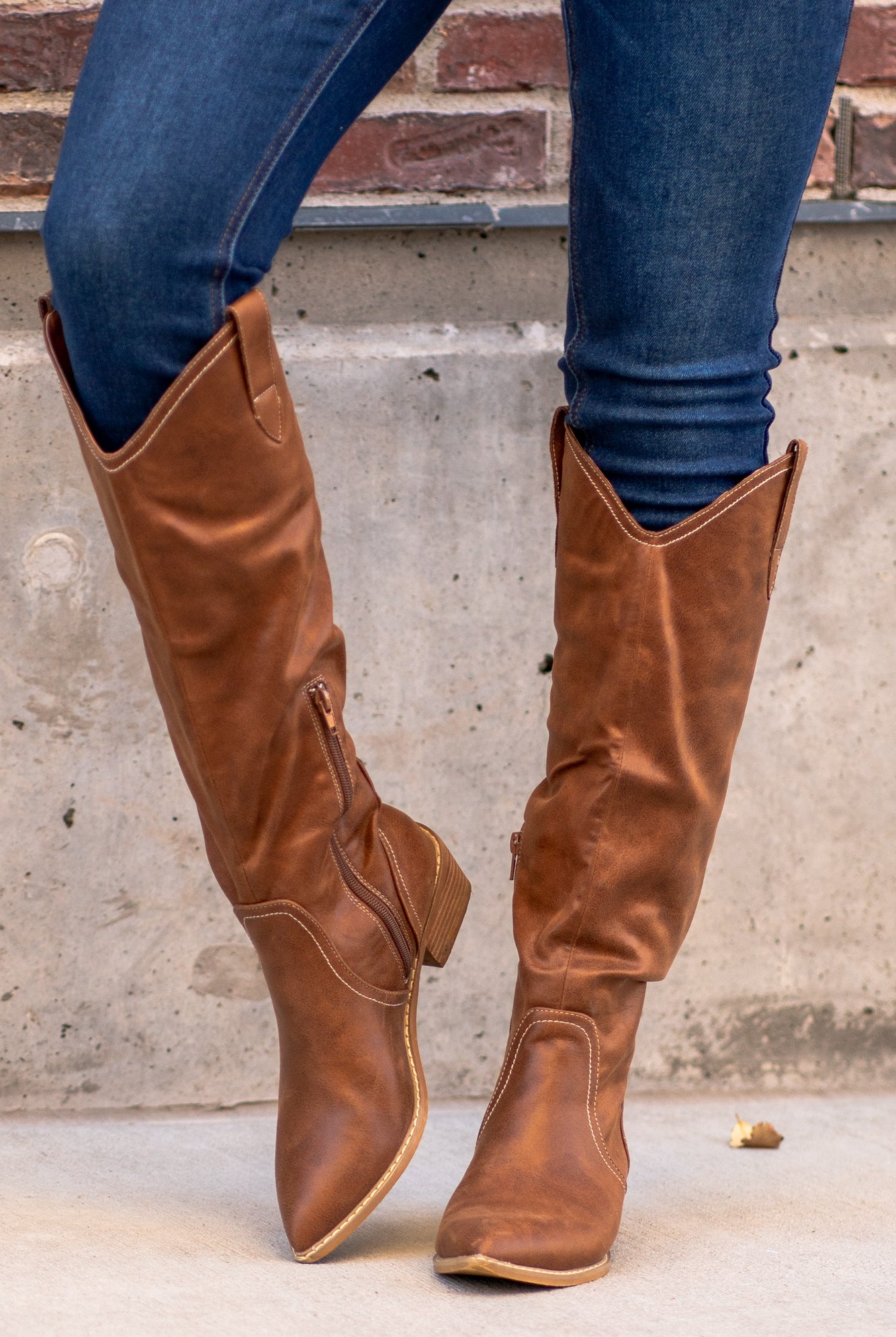Boots by Oasis Society  A riding knee-high boot with a zipper and block heel with a v cut to elongate the legs. Color: Brown Man-made Upper Leather Wrap heel Padded footbed Shaft Height: 15" Heel Height: 2" Contact us for any additional measurements or sizing. 