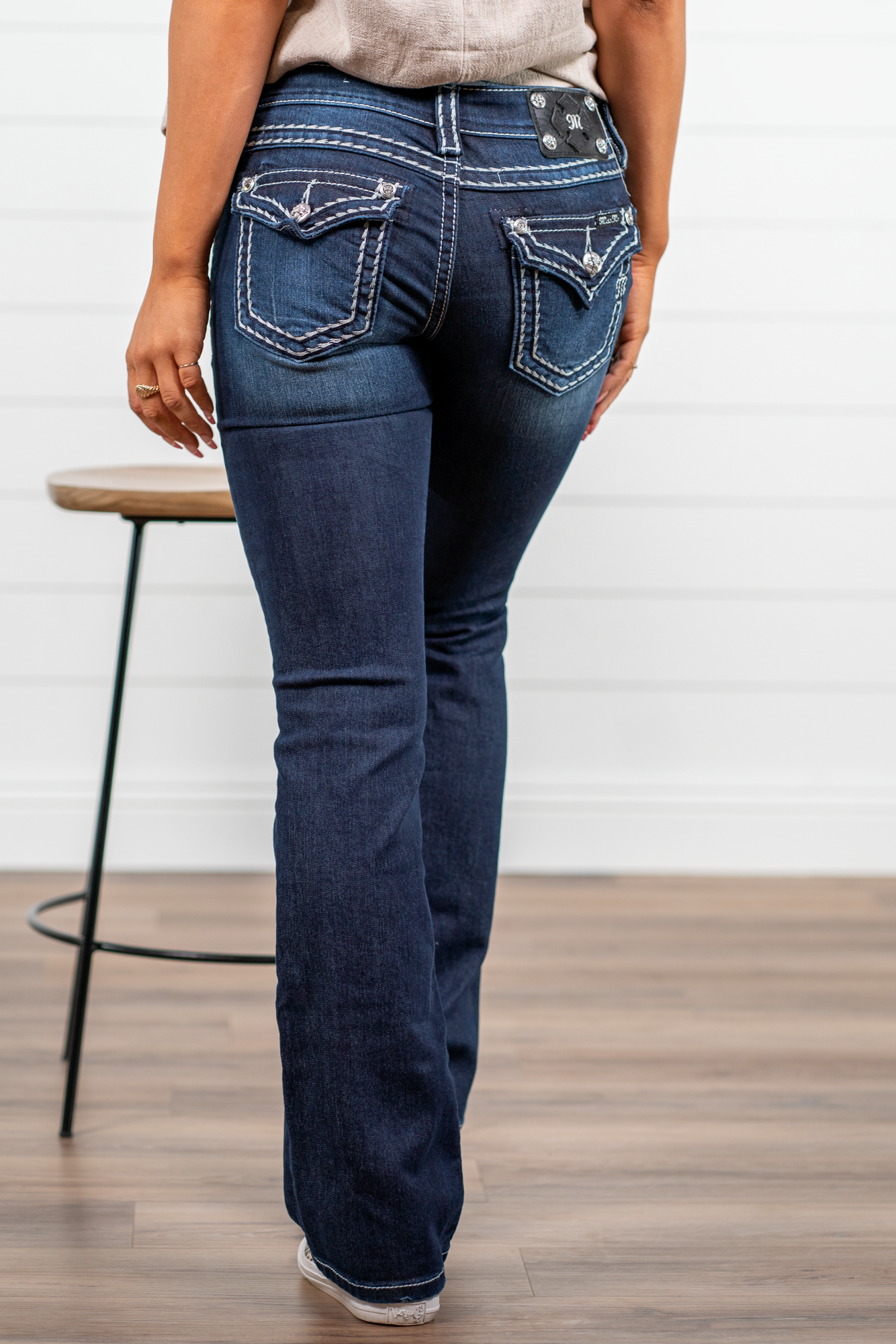 Miss Me Dark wash Bootcut jean with fading, whiskering, and white loose saddle stitching throughout. Jean is detailed with large crystal rivets and antique silver hardware. Inseam: 32" Boot Cut Wash: Dark Blue Low Rise, 7.5" Front Rise Silver Buttons and Rivets 73% Cotton; 25% Polyester; 2% Elastane Style #: JS5014B58V Contact us for any additional measurements or sizing. *Measured on the smallest size, measurements may vary by size.
