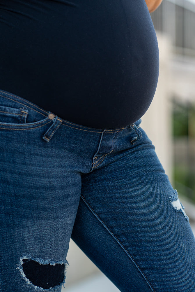 KanCan Maternity Jeans Do you miss wearing jeans? These maternity jeans will keep you comfy and cute with an elastic stretch waistband that fits over the tummy. Color: Dark Blue Wash Ripped Distressed Denim Patched Legs Fray Hem Detail Cut: Flare, 30" Inseam Rise: Mid-Rise with Full Tummy Band, 5.5" Material: 94% COTTON, 4% T-400, 2% SPANDEX Style #: KC3014D Contact us for any sizing questions or measurements.