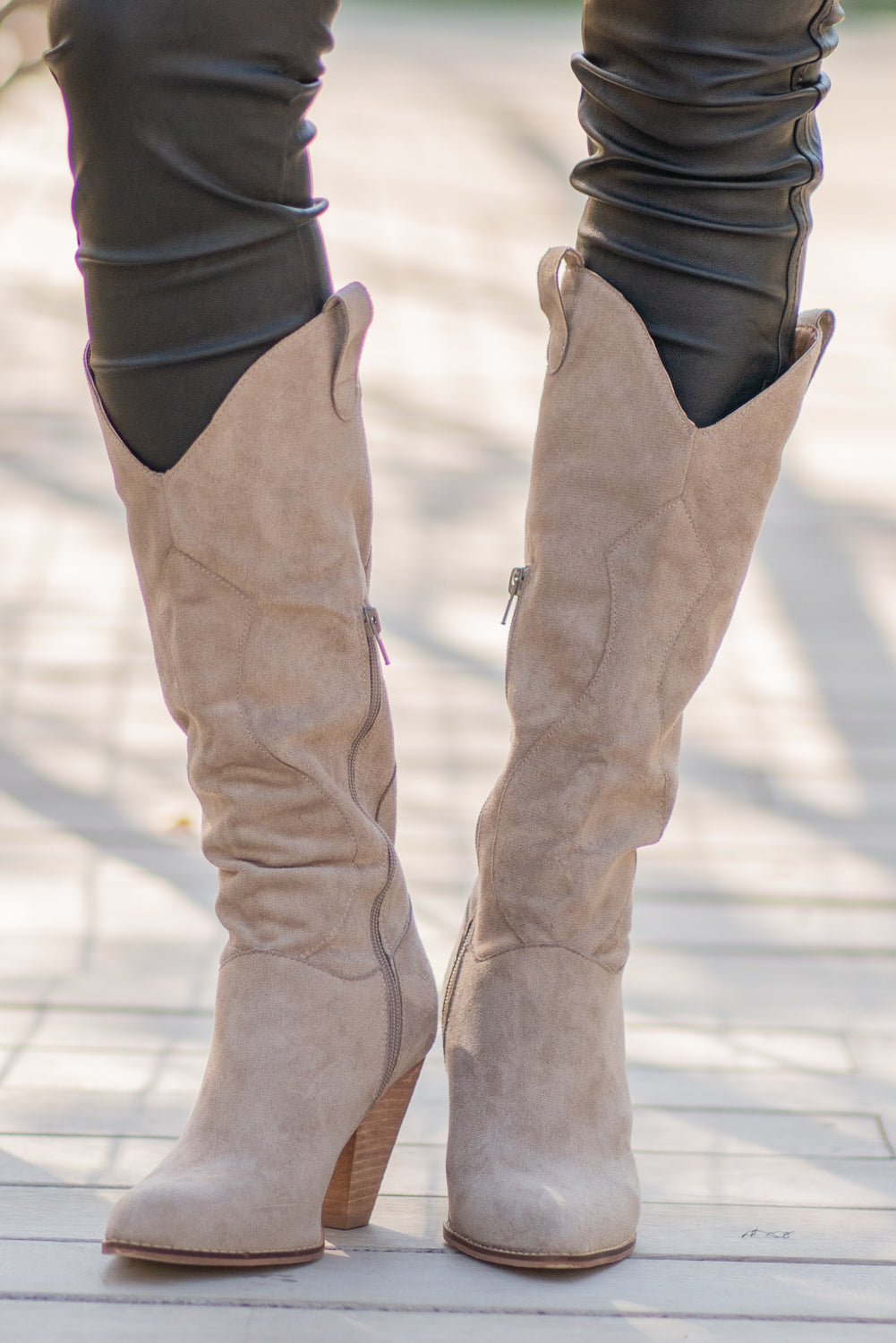 Boots by Mi.iM A western knee high boot with a zipper and block heel with a v cut to elongate the legs. Color: Taupe Man-made Upper Leather Wrap heel Padded footbed Shaft Height: 12" Heel Height: 3.5" Contact us for any additional measurements or sizing.