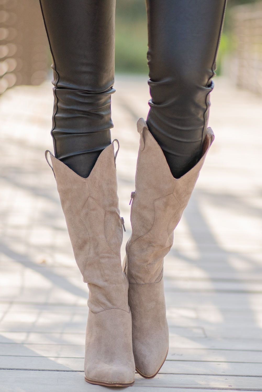 Boots by Mi.iM A western knee high boot with a zipper and block heel with a v cut to elongate the legs. Color: Taupe Man-made Upper Leather Wrap heel Padded footbed Shaft Height: 12" Heel Height: 3.5" Contact us for any additional measurements or sizing.