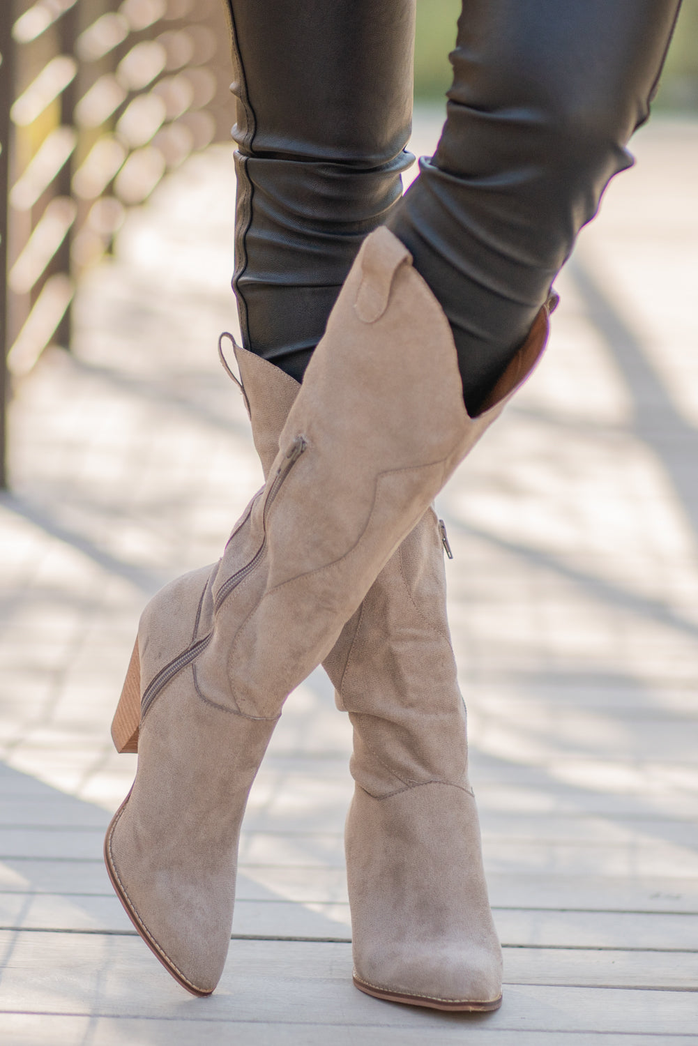Boots by Mi.iM A western knee high boot with a zipper and block heel with a v cut to elongate the legs. Color: Taupe Man-made Upper Leather Wrap heel Padded footbed Shaft Height: 12" Heel Height: 3.5" Contact us for any additional measurements or sizing.