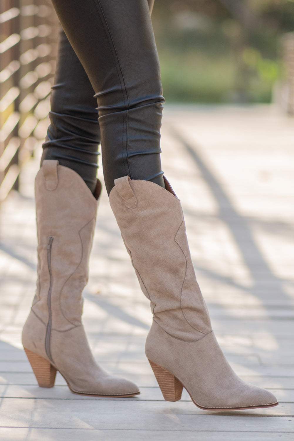 Boots by Mi.iM A western knee high boot with a zipper and block heel with a v cut to elongate the legs. Color: Taupe Man-made Upper Leather Wrap heel Padded footbed Shaft Height: 12" Heel Height: 3.5" Contact us for any additional measurements or sizing.