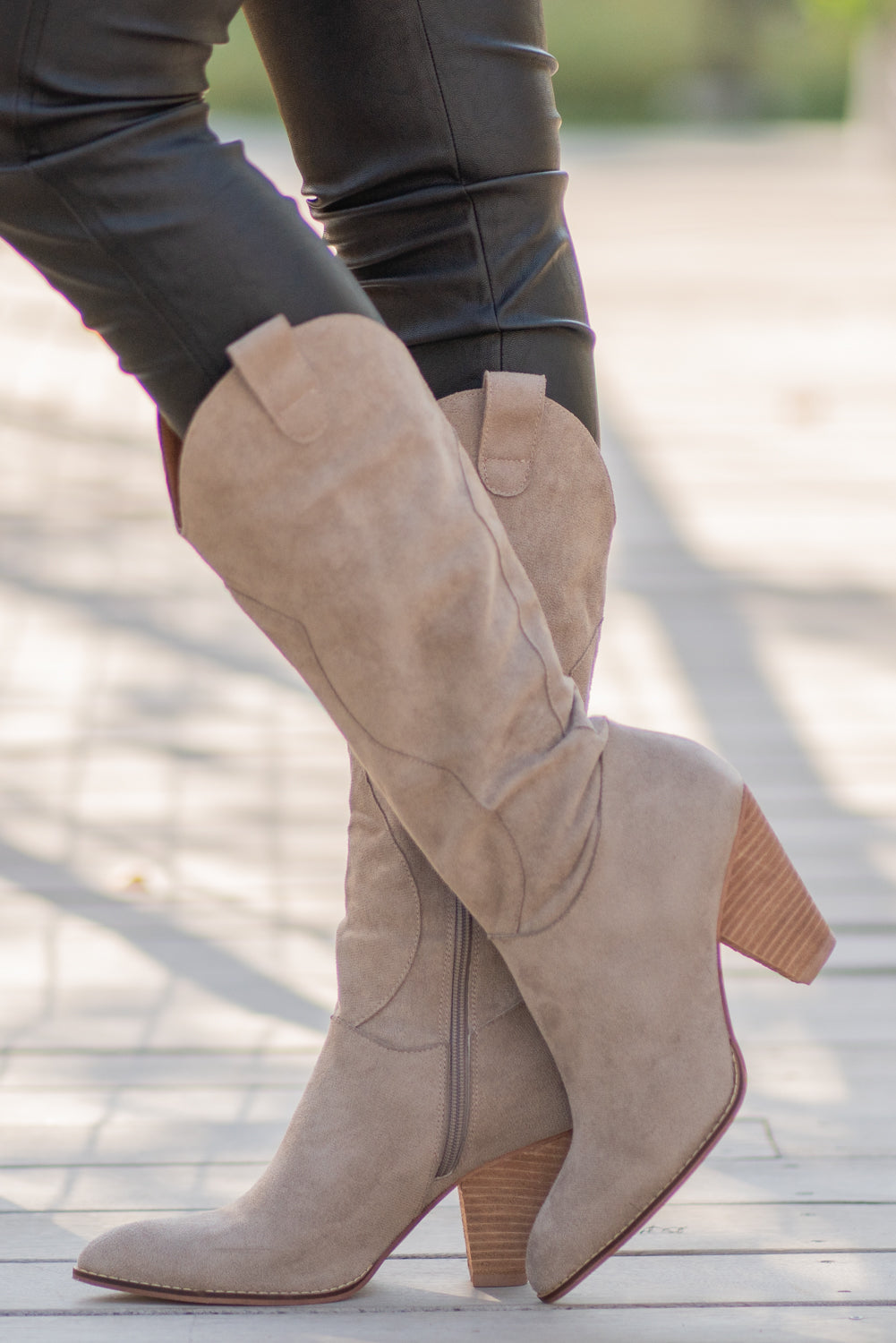 Boots by Mi.iM A western knee high boot with a zipper and block heel with a v cut to elongate the legs. Color: Taupe Man-made Upper Leather Wrap heel Padded footbed Shaft Height: 12" Heel Height: 3.5" Contact us for any additional measurements or sizing.