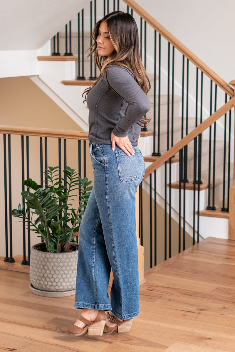 KanCan Jeans   Ultra High Rise 90s Wide Leg Jeans, a nod to the iconic '90s style. While they feature a rigid stretchiness level, these jeans offer a unique design with a hidden button fly, a dart on the back waist, and front slant pockets. The one-inch wide hem adds a trendy twist to complete the look. Color: Dark Wash Cut: FIT, 30" Inseam* Rise:-Rise, 11 1/2" Front Rise* Material: 100% Cotton, Rigid Stitching: Classic Fly: Button Fly Style #: KC7948D