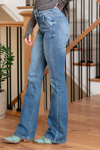 KanCan Jeans   Introducing the Alora High Rise Bootcut jeans, a perfect fusion of style and comfort. These jeans feature a flattering high rise and a bootcut leg for a timeless silhouette. The comfort stretch ensures flexibility for all-day wear. Stand out with the double waistband detail and curved yoke, adding a touch of uniqueness to your look