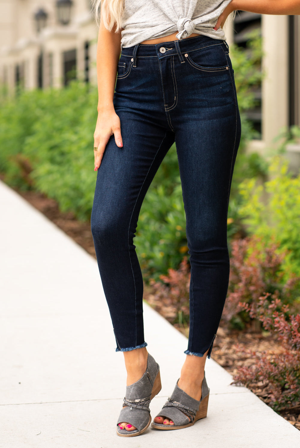 KanCan Jeans These high rise dark wash skinny jeans have a spilt fray hem and fit above the ankles so you can show off you sandals this summer. Color: Dark Blue Cut: Skinny, 27.5" Inseam Rise: High-Rise, 10.5" Front Rise COTTON 71% POLYESTER 27% SPANDEX 2% Stitching: Classic Fly: Zipper Style #: KC8604D Contact us for any additional measurements or sizing.  Cas is 5'7", wears a size 25 jeans, small top and 8 shoe. She is wearing a size 25/3 in these jeans. 