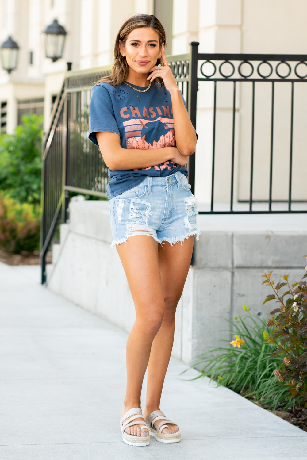 KanCan Jeans Light blue denim with distress and a raw hem for a lived-in look that's perfect for the summer season. Our Estella High Rise Shorts sit above the natural waistline for a trendy fit that will never go out of style. Made with rigid denim that holds its shape while allowing you to move with ease. Features a classic five-pocket design, single-button front, and zip-fly closure.