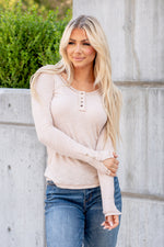 This long sleeve Henley top is great for layering up or down during winter and pairs well with any denim.  Color: Beige Button Up Front Henley with Button Sleeve Detail Neckline: Round Sleeve: Long Sleeve Self - 60% POLYESTER/32% COTTON/8% SPANDEX Style #: JAT7559-Beige Contact us for any additional measurements or sizing.