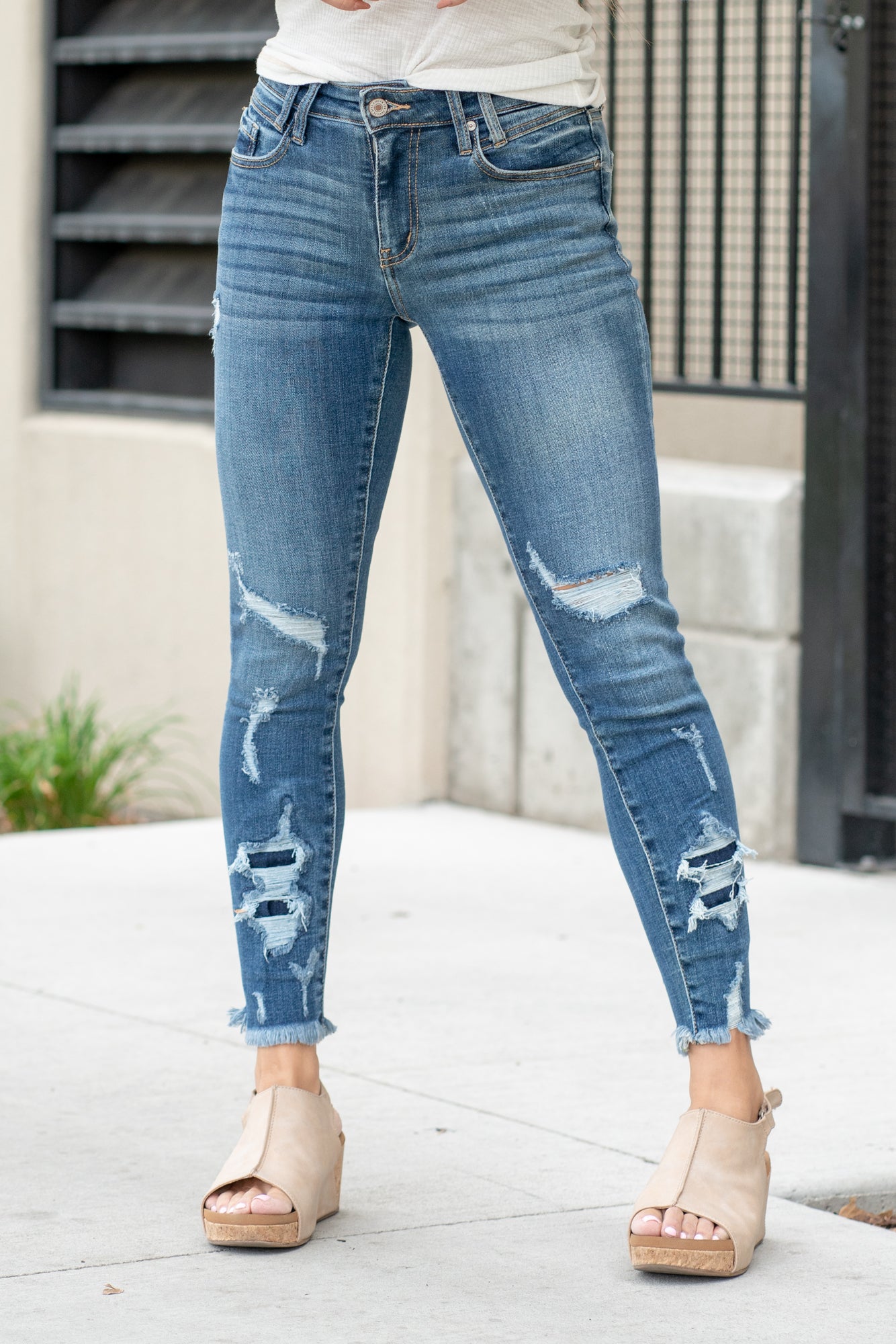 KanCan Jeans  Parkersburg are KanCans ankle skinny with a mid-rise fit. These have a fitted leg with a denim patch distress and a whiskered wash in medium blue.  Color: Medium Wash Ankle Skinny, 27" Inseam* Mid Rise, 9.25" Front Rise* Dyed Side Seam 93% COTTON , 6% POLYESTER , 1% SPANDEX Fly: Zipper Style #: KC2516M Contact us for any additional measurements or sizing.  