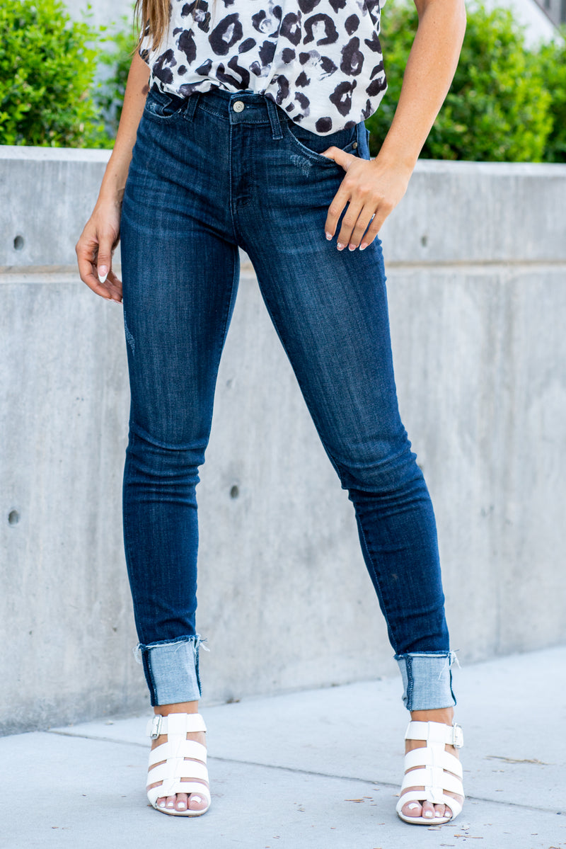Judy Blue  A dark wash mid-rise skinny with a folded hem that can be unfolded to add length for longer inseams. Color: Medium Blue  Cut: Skinny fit, 28.5" Cuffed* | 32" Inseam Uncuffed* Mid Rise, 9.75" Front Rise* Material: 52% Cotton, 23% Polyester, 22% Rayon, 3% Spandex Stitching: Classic Fly: Zipper Fly Style #: JB82340 | 82340 Contact us for any additional measurements or sizing.    *Measured on the smallest size, measurements may vary by size.   