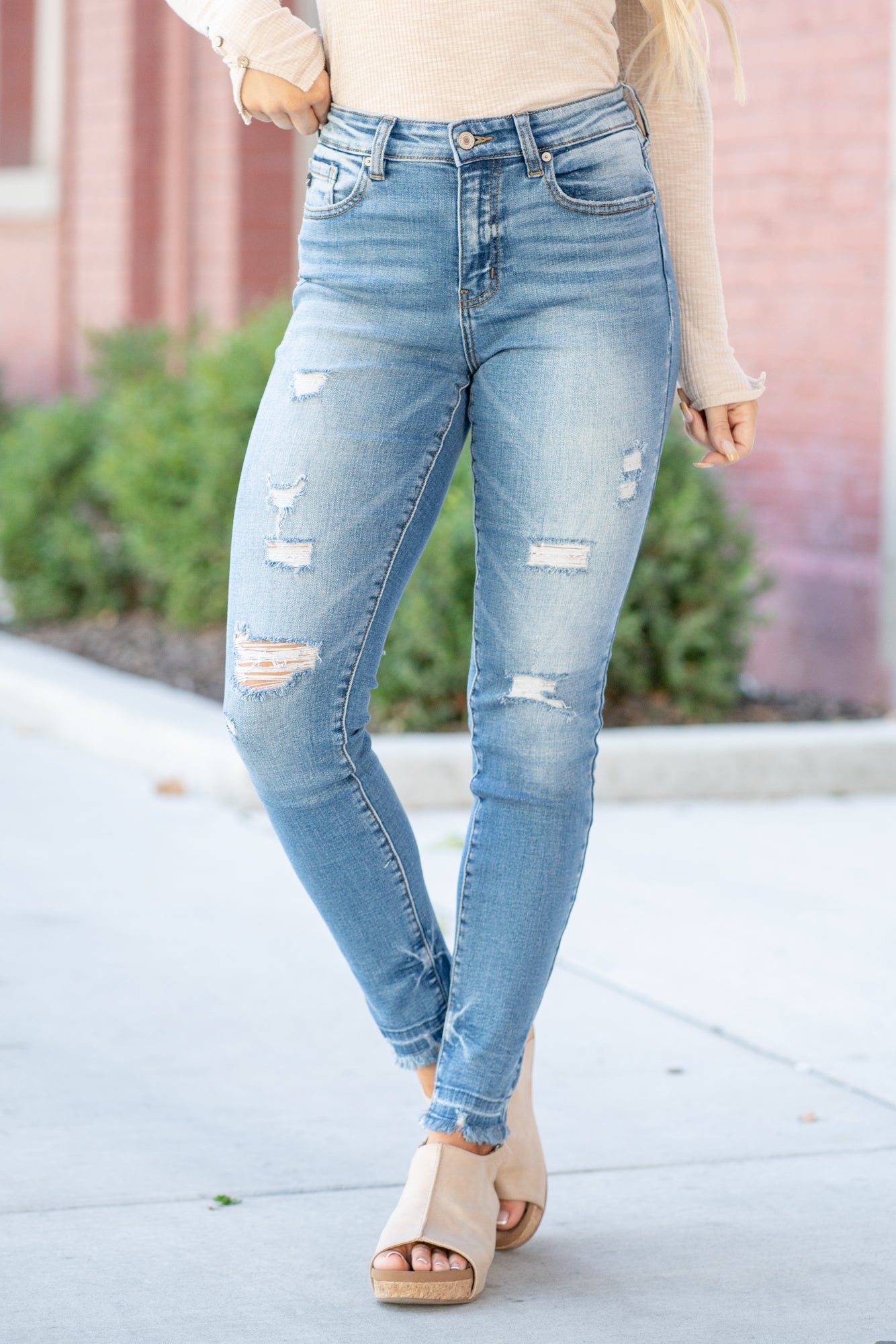 KanCan Jeans  These high-rise dark wash skinny jeans have a slightly distressed hem with a fitted skinny leg. Color: Medium Blue Cut: Skinny, 29.5" Inseam* Rise: High-Rise, 9.75" Front Rise* 98% COTTON 2% SPANDEX Stitching: Classic  Fly: Zipper Style #: KC8347M Contact us for any additional measurements or sizing.    *Measured on the smallest size, measurements may vary by size.   Cas is 5'7" and wears a size 25 in jeans, a small in tops, and 8 in shoes. She is wearing size 25 in these jeans. 