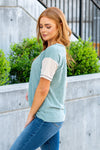 BiBi   Color: Sage Neckline: Round with Henley Style Buttons Sleeve: Short Sleeve Material: Cotton/Spandex Mix Style #: BT2419-02-Sage Contact us for any additional measurements or sizing.   