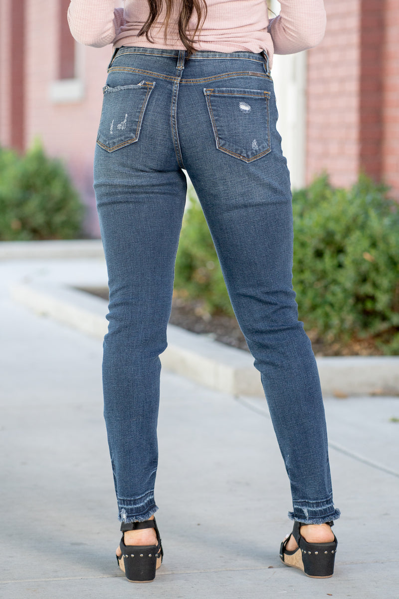 KanCan Jeans  These high-rise dark wash skinny jeans have a slightly distressed hem with a fitted skinny leg. Color: Dark Blue Cut: Skinny, 29.5" Inseam* Rise: High-Rise, 9.75" Front Rise* 98% COTTON 2% SPANDEX Stitching: Classic  Fly: Zipper Style #: KC8347D Contact us for any additional measurements or sizing.