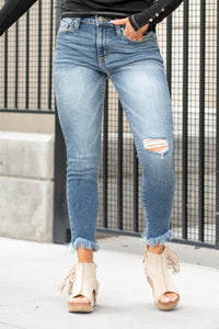 KanCan Jeans  An ankle skinny fit with a mid-rise and frayed hem. These have a fitted leg with distress and a whiskered wash in medium blue.  Color: Medium Wash Ankle Skinny, 26.5" Inseam* Mid Rise, 9.5" Front Rise* 94% COTTON, 5% POLYESTER, 1% SPANDEX Fly: Zipper Style #: KC9291M Contact us for any additional measurements or sizing.   *Measured on the smallest size, measurements may vary by size.  Sarah wears a size 25 in jeans, a small in tops, and 8 in shoes. She is wearing size 25 in these jeans. 