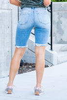 VERVET by Flying Monkey Jeans  These comfortable bermuda shorts have a distressed hem detail. Pair with a graphic tee and sandals. Shorts, 3.5" Inseam*   High Rise, 10" Front Rise* 98% Cotton, 2% Spandex Stitching: Classic Fly: Zipper  Style #: V2929 Contact us for any additional measurements or sizing.    *Measured on the smallest size, measurements may vary by size. 