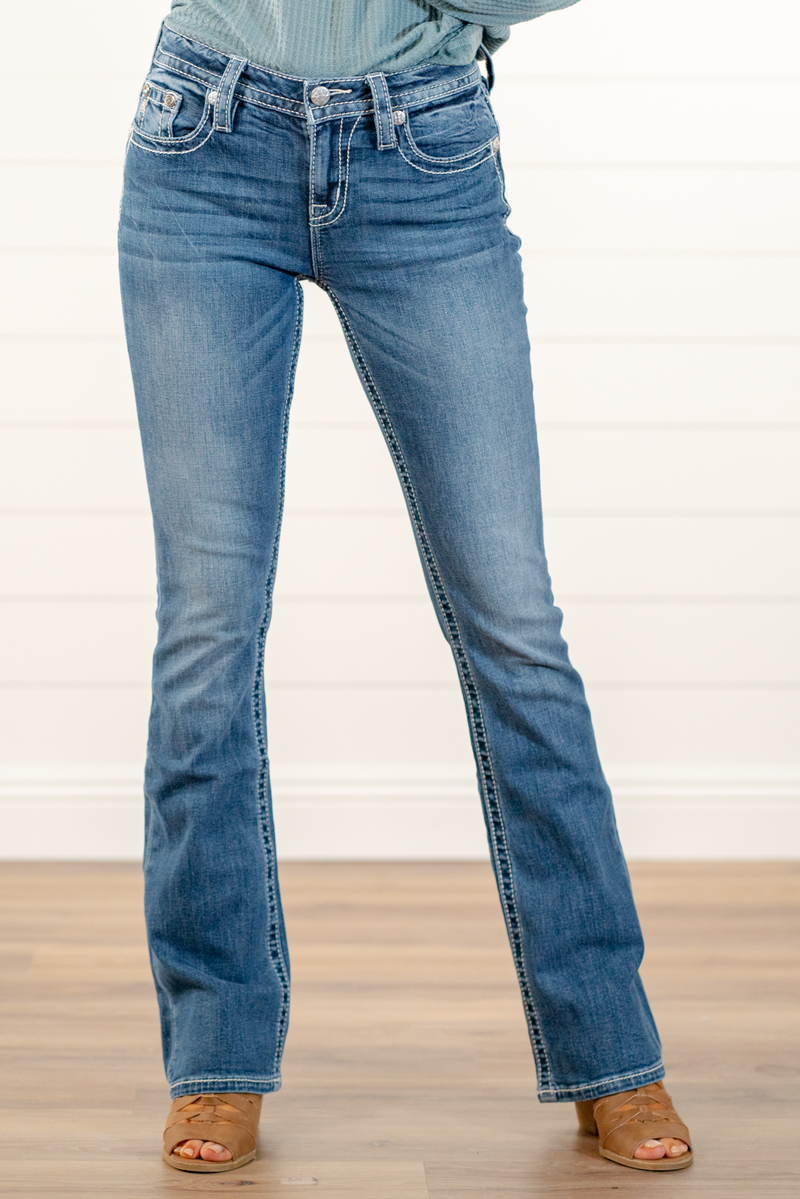 Miss Me  Wear these cross pockets jeans every day to bling up your wardrobe. Boot cut jeans featuring a 5 pocket design, whiskering, and crystal rivets. Wash: Dark Blue Inseam: 34" Bobot Cut* Mid Rise, 8.75" Front Rise* Silver Buttons and Rivets  Style #: M3742B3  Contact us for any additional measurements or sizing.    *Measured on the smallest size, measurements may vary by size.  