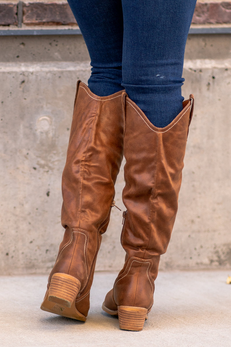 Boots by Oasis Society  A riding knee-high boot with a zipper and block heel with a v cut to elongate the legs. Color: Brown Man-made Upper Leather Wrap heel Padded footbed Shaft Height: 15" Heel Height: 2" Contact us for any additional measurements or sizing. 