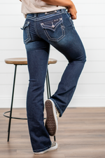 Miss Me  Dark wash Bootcut jean with fading, whiskering, and white loose saddle stitching throughout. Jean is detailed with large crystal rivets and antique silver hardware.  Inseam: 32" Boot Cut Wash: Dark Blue Low Rise, 7.5" Front Rise Silver Buttons and Rivets  73% Cotton; 25% Polyester; 2% Elastane Style #: JS5014B58V Contact us for any additional measurements or sizing.  *Measured on the smallest size, measurements may vary by size. 
