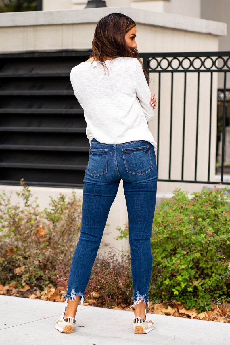 Judy Blue  These distressed hem relaxed fit jeans will be your comfiest Judy Blues yet! With relaxed legs and a mid-waist, you will want to wear these every day!   Color: Dark Blue Cut: Relaxed Fit, 27" Inseam* Rise: Mid Rise. 9.5" Front Rise* Material: 66% COTTON,21% POLYESTER,11% RAYON,2% SPANDEX Machine Wash Separately In Cold Water Stitching: Classic Fly: Zipper Style #: JB82227 , 82227  Contact us for any additional measurements or sizing. 