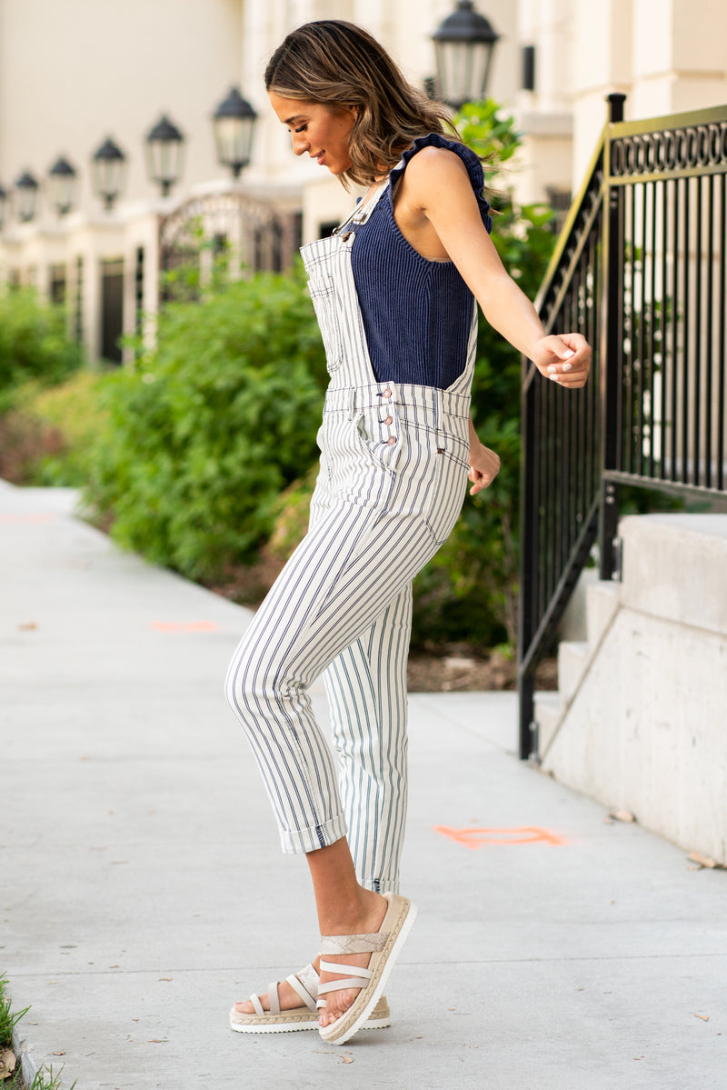 Judy Blue Jeans  Add some fun into your life with these cute striped boyfriend-fit overalls! Collection: Spring 2021 Color: Navy Blue Striped with Wite Cut: Boyfriend Overalls, 27" Inseam  Rise: 10" Front Rise 64.7% COTTON,21% RAYON,12.9% polyester,1.4% SPANDEX Fly: Zipper Fly Style #: JB88222-White | 88222-WT Contact us for any additional measurements or sizing. 