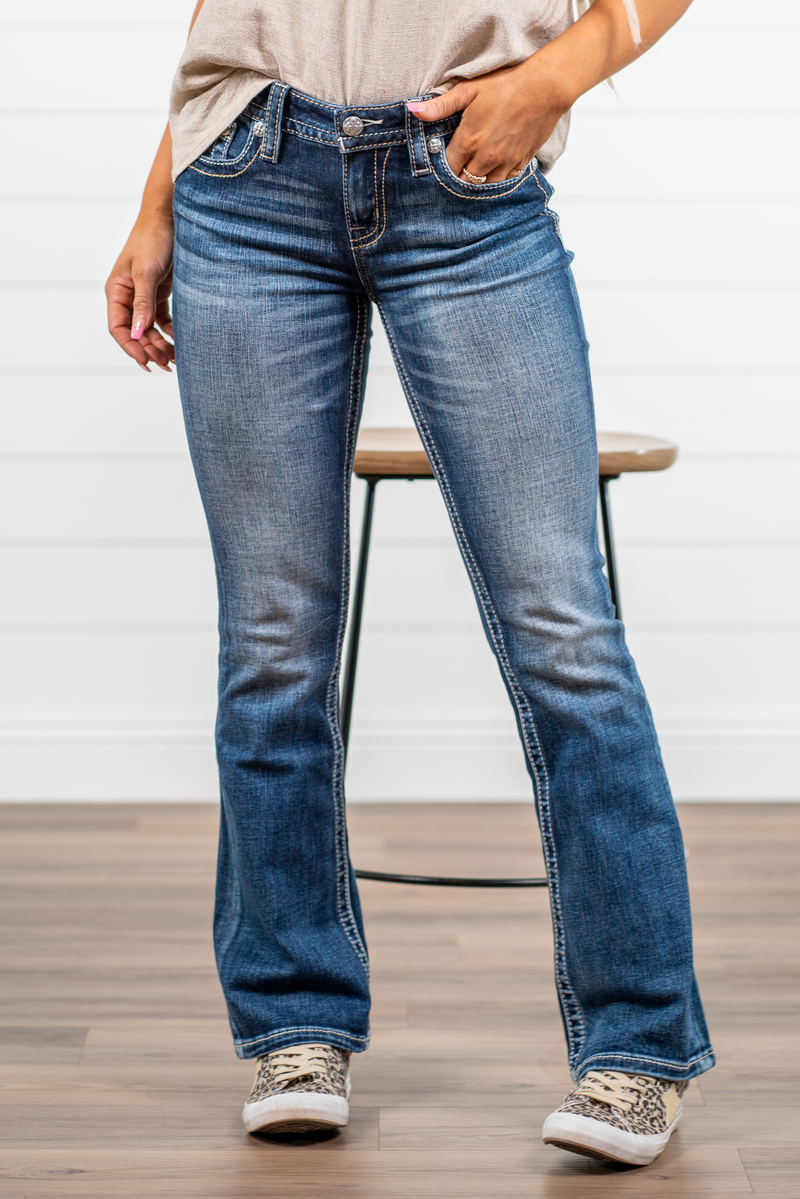 Miss Me  Dark wash Bootcut jean with fading, whiskering, and white loose saddle stitching throughout. Jean is detailed with large crystal rivets and antique silver hardware.  Inseam: 32" Boot Cut Wash: Dark Blue Mid Rise, 8.5" Front Rise Silver Buttons and Rivets  99% Cotton; 1% Elastane Style #: M3444B42V Contact us for any additional measurements or sizing.  *Measured on the smallest size, measurements may vary by size. 