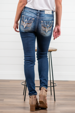 Miss Me  Elevate your style with this must have skinny detailed with contrast stitching, whiskering, embroidered steer and faux flap pocket with rhinestone rivets. Wash: Dark Blue Inseam: 30" Skinny Cut Mid Rise, 9" Front Rise Silver Buttons and Rivets 73% Cotton, 24% Viscose, 3% Elastane Style #: M3800S Contact us for any additional measurements or sizing.  *Measured on the smallest size, measurements may vary by size. 