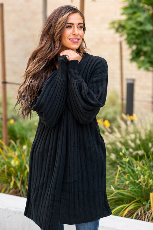 Blue Buttercup  Pair your favorite cami and jeans with this cute open front cardigan.    Color: Black  Neckline: Open  Sleeve: Long  Style #: SW60013 Contact us for any additional measurements or sizing.     