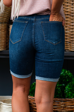Judy Blue Jeans Color: Dark Blue Shorts   Cut: Bermudas Shorts, 8.5" Inseam  Rise: 10.5" Front Rise 91% COTTON,7% POLYESTER,2% RAYON Stitching: Classic  Fly: Zipper Fly Style #: JB150115-DK | 150115-DK Contact us for any additional measurements or sizing.  *Measured on the smallest size, measurements may vary by size. 