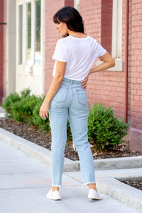 Cello Jeans  Beautifully balanced, these mom jeans offer a soft 100% cotton material with a cross-over button closure. Their destructed detailing and light blue wash make them a must-have.  Color: Light Blue Wash Cut: Slim Straight Fit, 28" Inseam Rise: High-Rise, 10.5" Front Rise 100% Cotton Fly: Zipper Style #: WV17818M-LTD Contact us for any additional measurements or sizing.