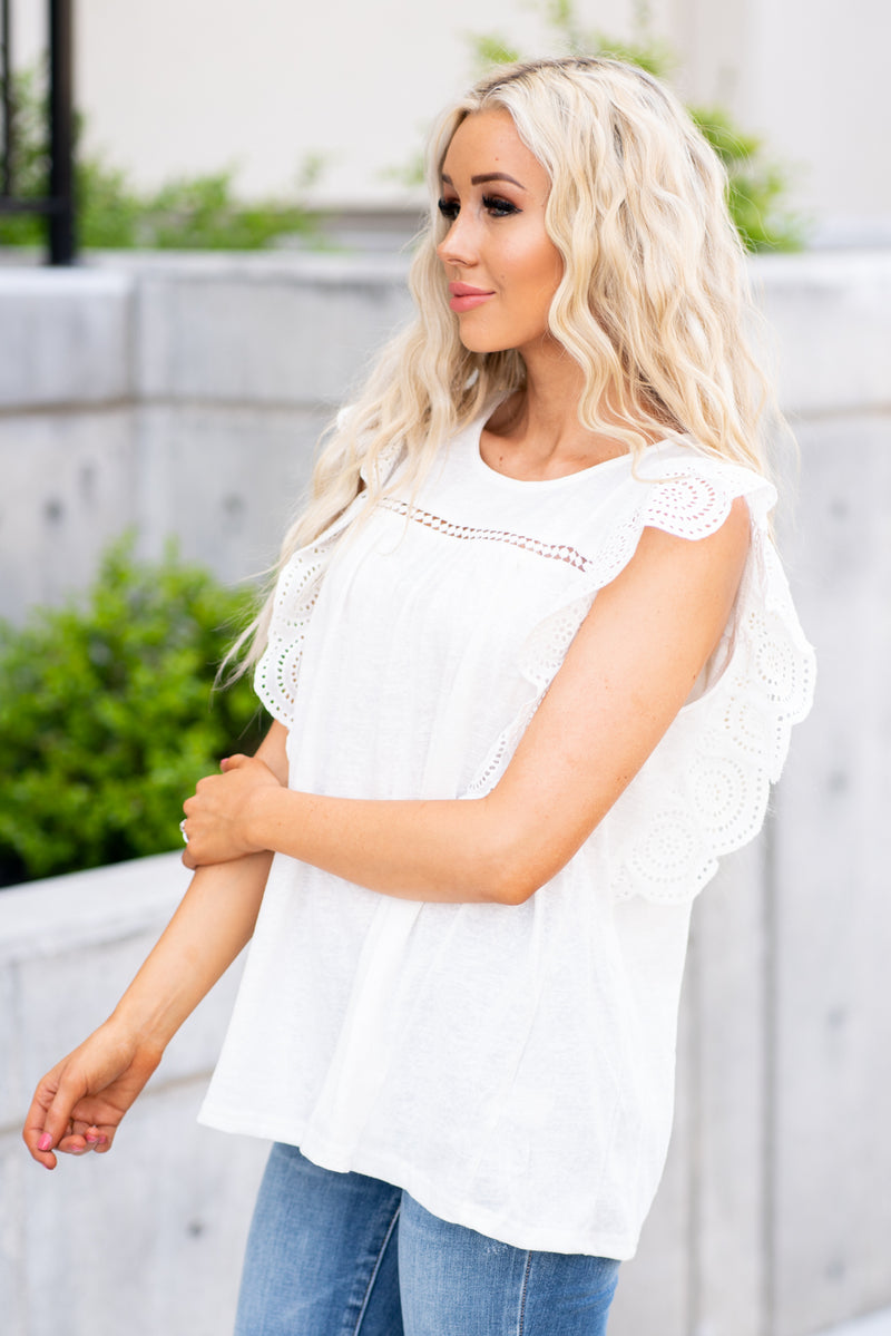 BiBi   Dress up your denim with this ruffle sleeve top.  Collection: Spring 2021 Color: White Neckline: Round Sleeve: Short   Style #: IP4055 Contact us for any additional measurements or sizing. 