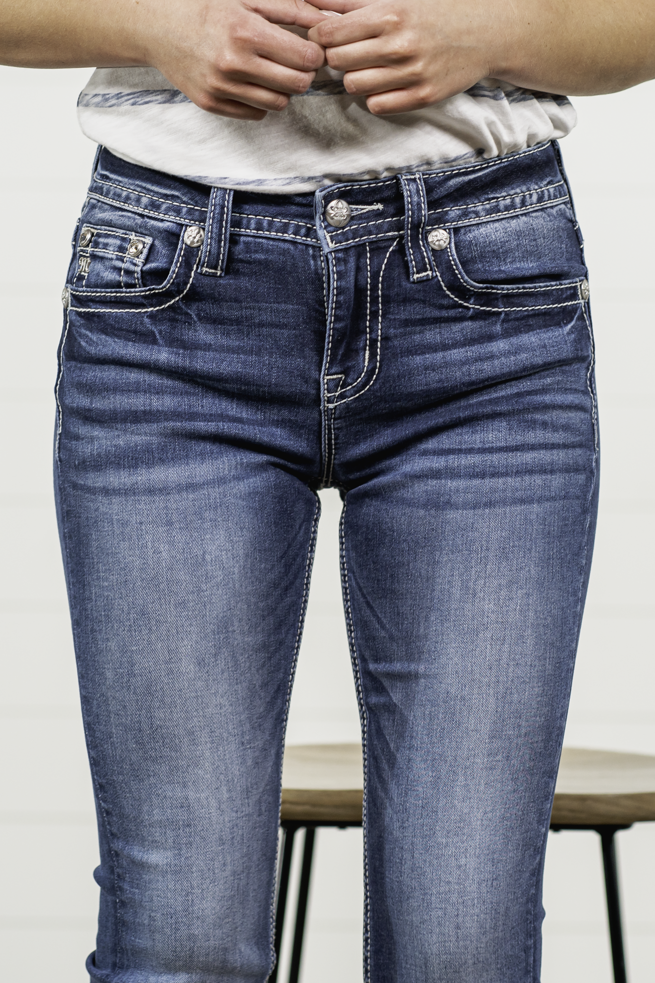 Miss Me  Stay sassy and sweet in this bootcut detailed with whiskering, distressing, and embroidered back pocket with rhinestone rivets. Wear these every day to bling up your wardrobe. Wash: Medium Blue  Inseam: 34" Boot Cut* Mid Rise, 9" Front Rise* Silver Buttons and Rivets Bright Clear Crystals Fading & Whiskering Details 91% Cotton 6% Polyester 3% Elastane  Style #: M3845B Contact us for any additional measurements or sizing.    *Measured on the smallest size, measurements may vary by size.   