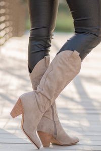 Boots by Mi.iM  A western knee high boot with a zipper and block heel with a v cut to elongate the legs. Color: Taupe Man-made Upper Leather Wrap heel Padded footbed Shaft Height: 12" Heel Height: 3.5" Contact us for any additional measurements or sizing. 