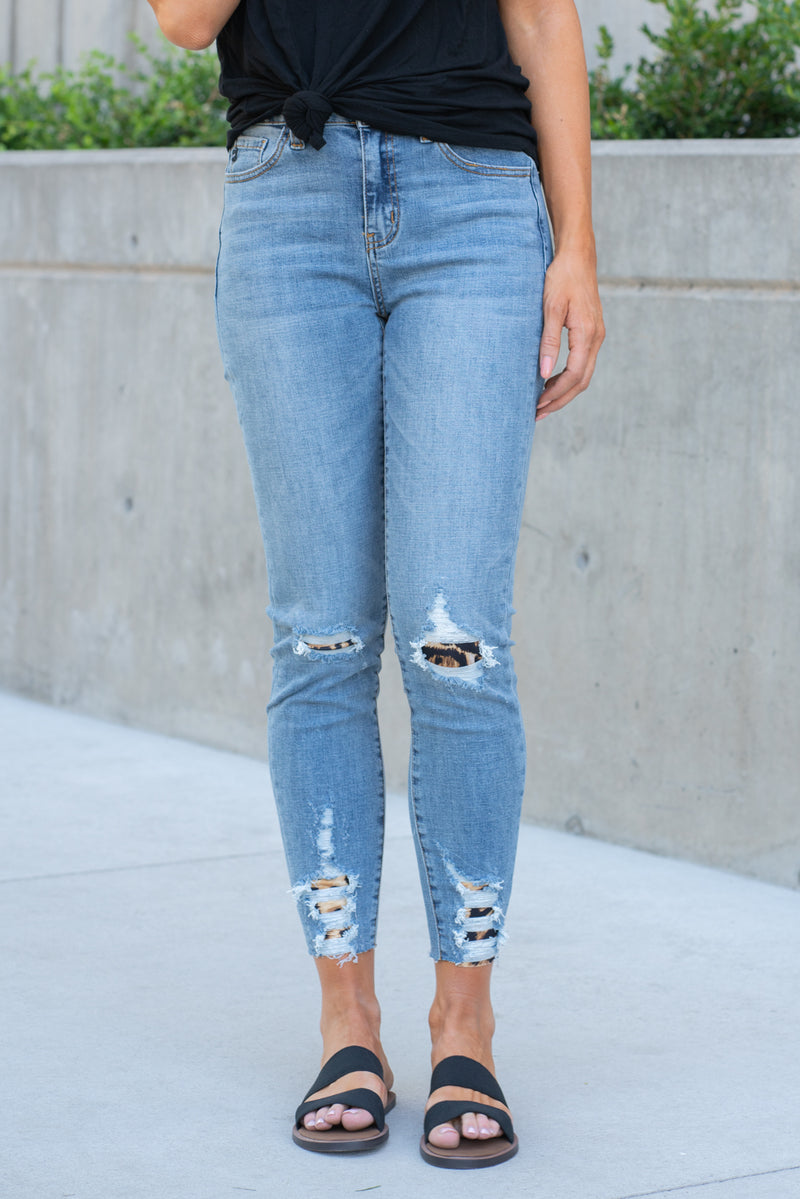 KanCan Jeans  Collection: Summer 2020 Style Name: Cheetah Leopard Patch Color: Medium Blue Wash Cut: Ankle Skinny, 27" Inseam Backed Distressed with Cheetah Spandex Material Rise: High-Rise, 9.5" Front Rise 98% Cotton 2% Elastane Fly: Zipper Style #: KC6237M Contact us for any additional measurements or sizing.