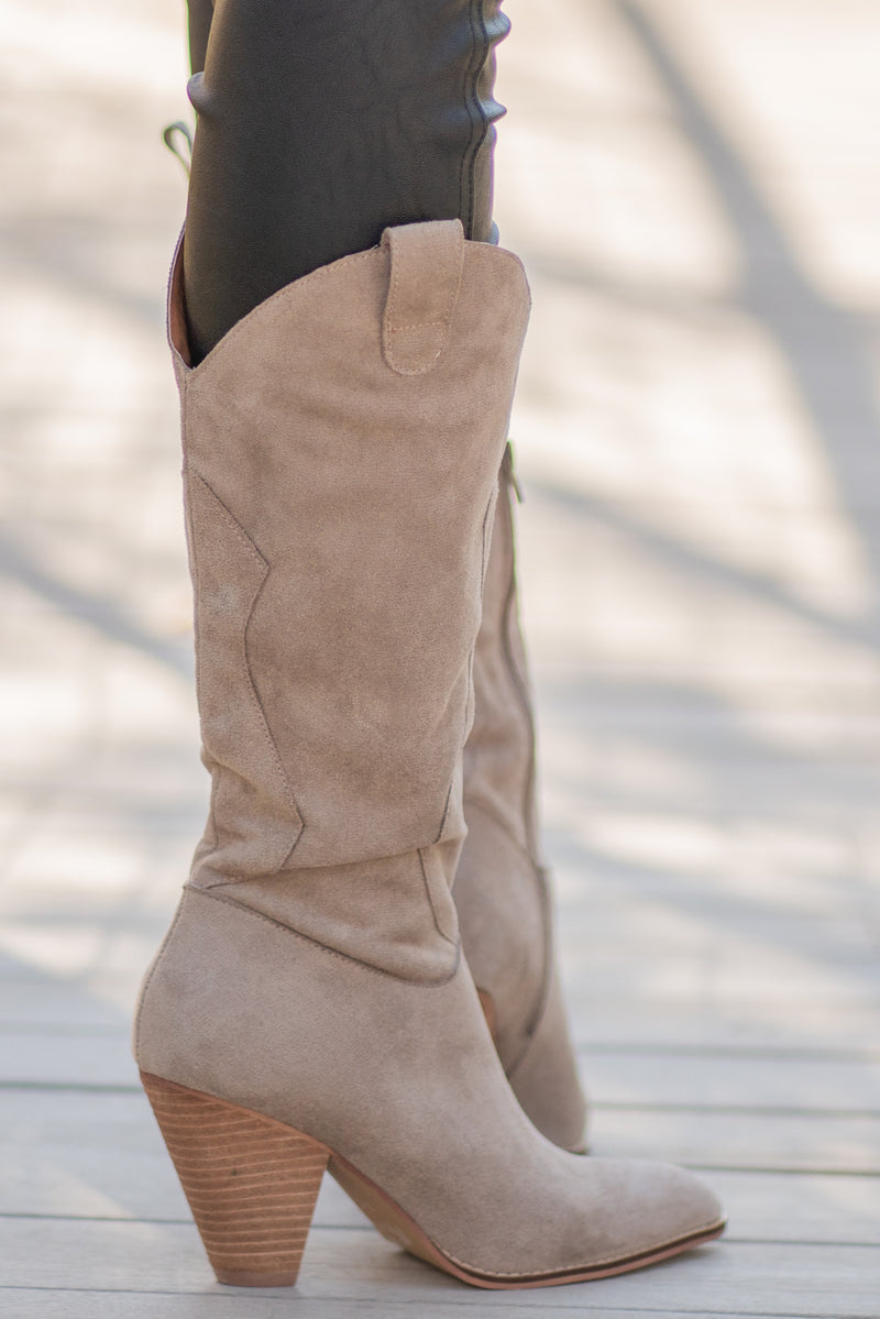 Boots by Mi.iM  A western knee high boot with a zipper and block heel with a v cut to elongate the legs. Color: Taupe Man-made Upper Leather Wrap heel Padded footbed Shaft Height: 12" Heel Height: 3.5" Contact us for any additional measurements or sizing. 