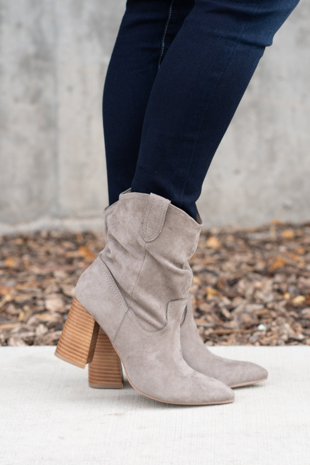 Boots by Mi.iM  This city-slick cowboy style bootie kicks it up a notch with a bold stacked heel. Crafted from manmade suede, this upper is completed with a slight slouch in the ankle. Finished on our signature padded foot bed, they're a must for all day comfort.  Man-made Upper Color: Grey Padded footbed Shaft Height: 5.75" Heel Height: 3.25" Opening: 12" Contact us for any additional measurements or sizing. 
